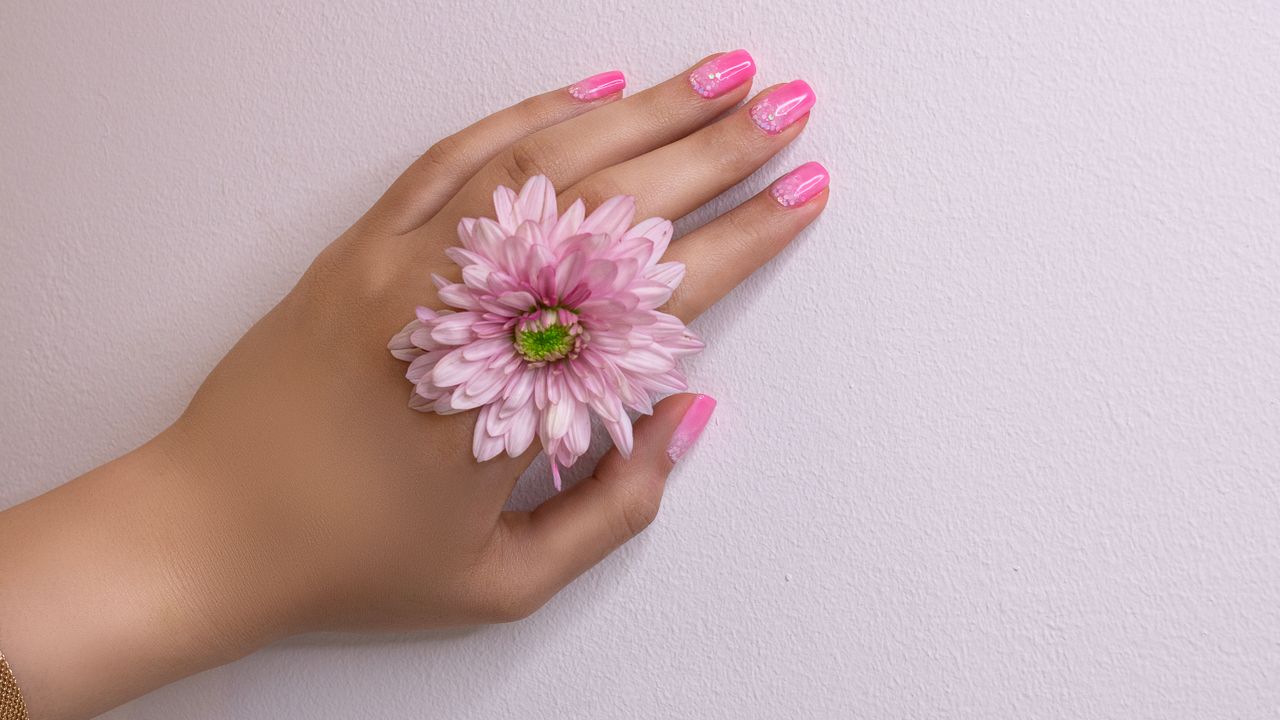 Mano con uñas rosas terminadas