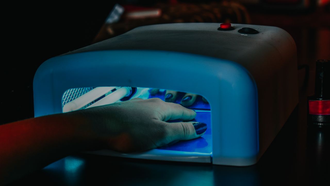 Uñas curándose bajo la lámpara LED tras aplicar el esmalte en gel